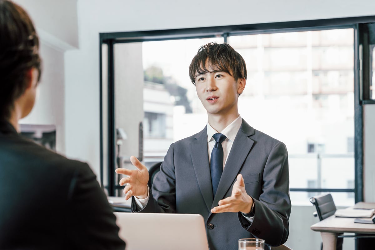 A young businessman man who explains and presents to a face -to -face person in the office